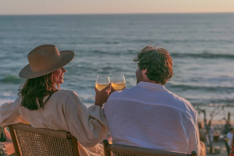 A couple enjoying a quiet sunset toast beside the sea